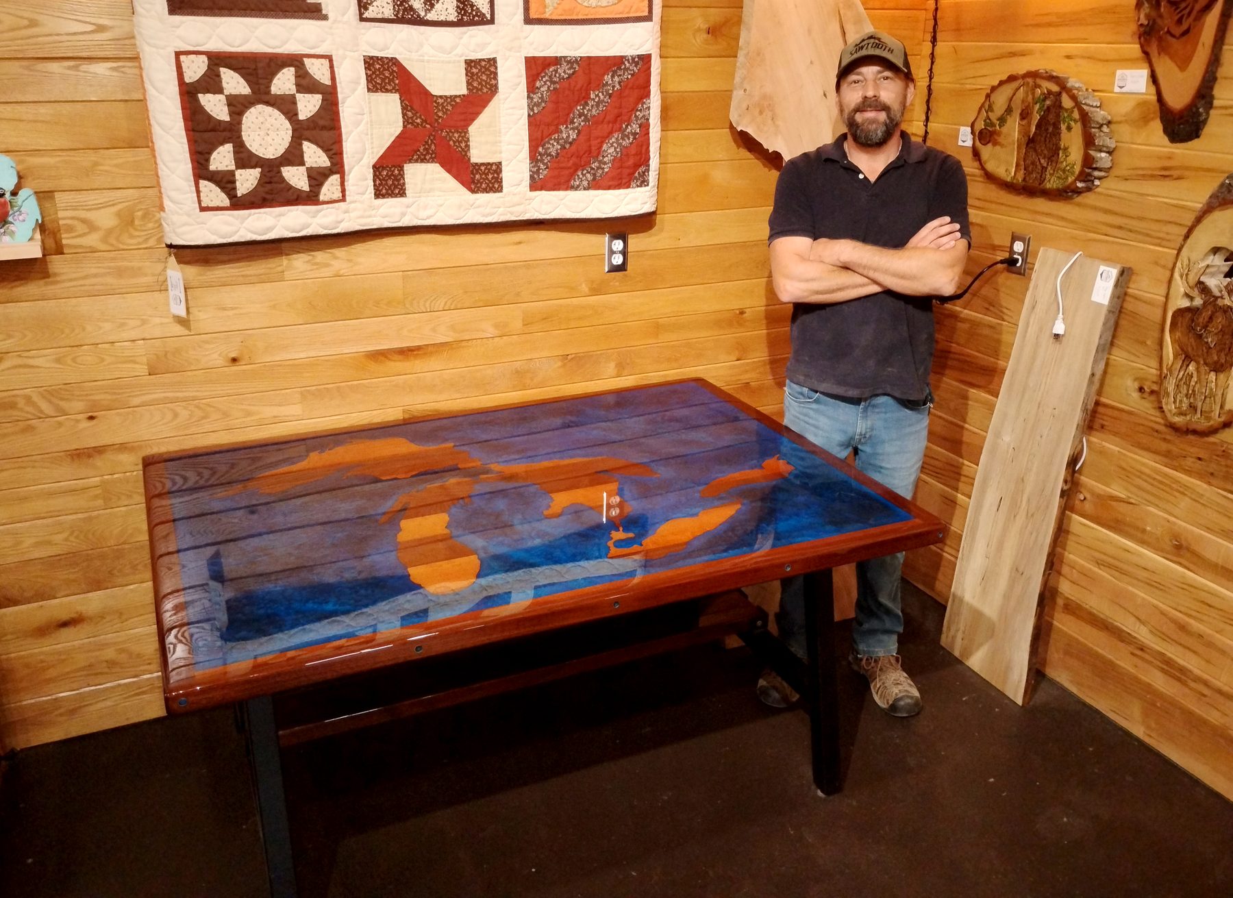 Dimitri Jansen standing beside a custom epoxy Michigan table